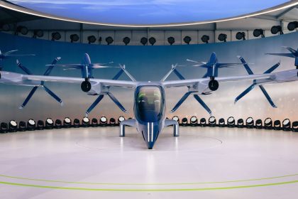 Protótipo de veículo elétrico futurista com hélices exposto em ambiente interno.
