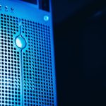 Rack de servidores iluminado em azul dentro de um datacenter moderno.