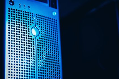 Rack de servidores iluminado em azul dentro de um datacenter moderno.